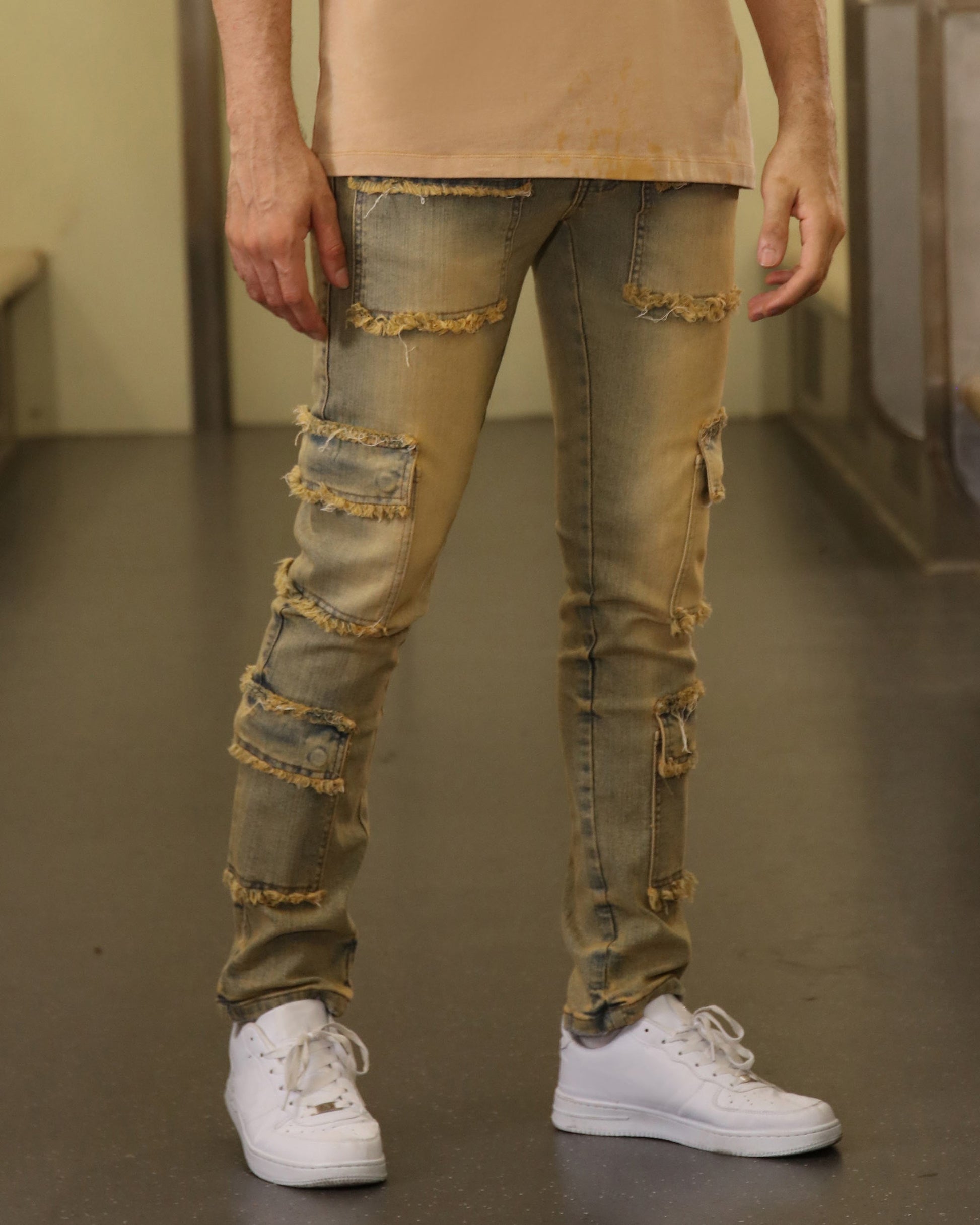 Logeqi raw edge brown jeans with distressed patches and frayed hems worn with white sneakers