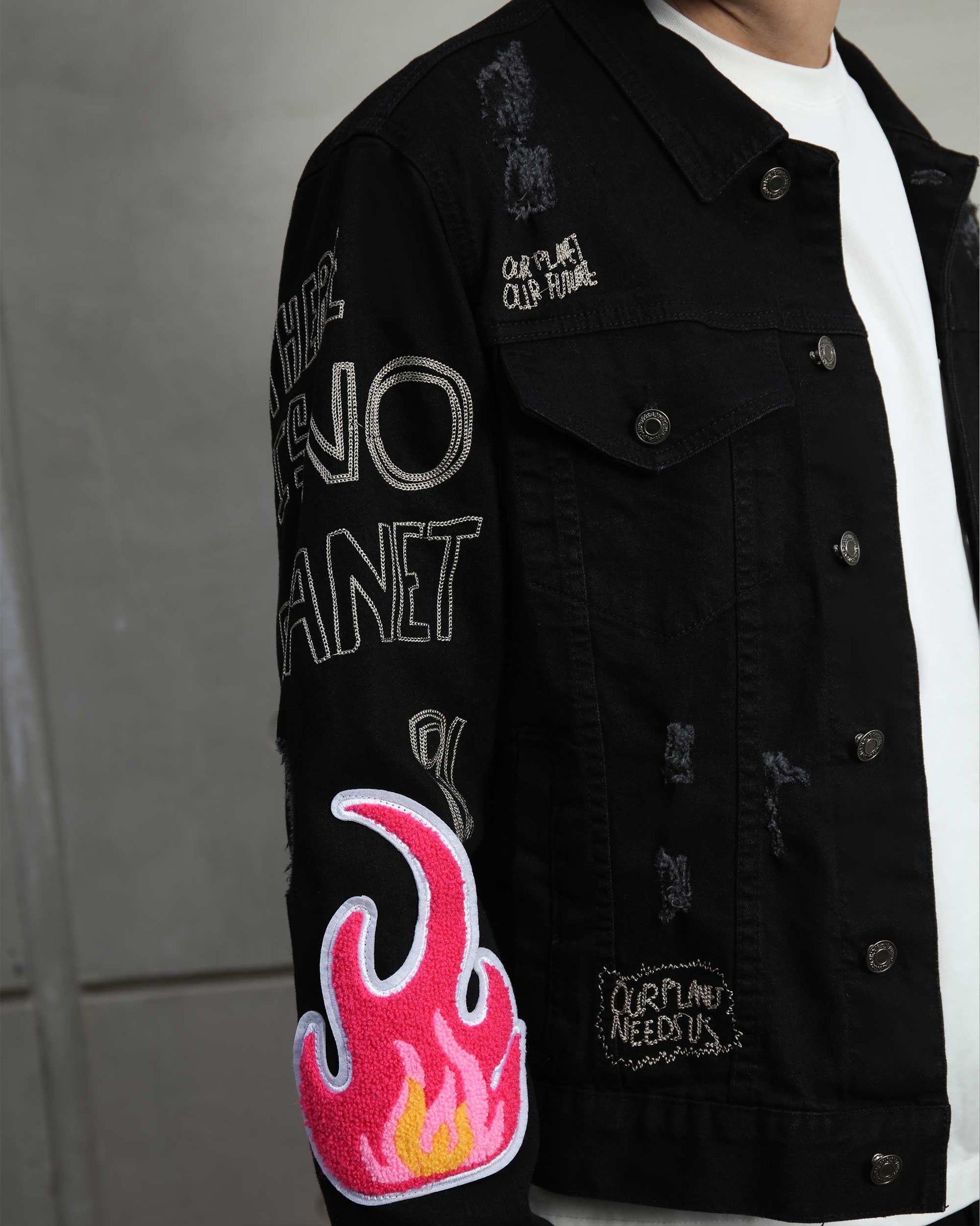 Ripped black denim jacket by Logeqi featuring unique flame and embroidered designs on sleeves