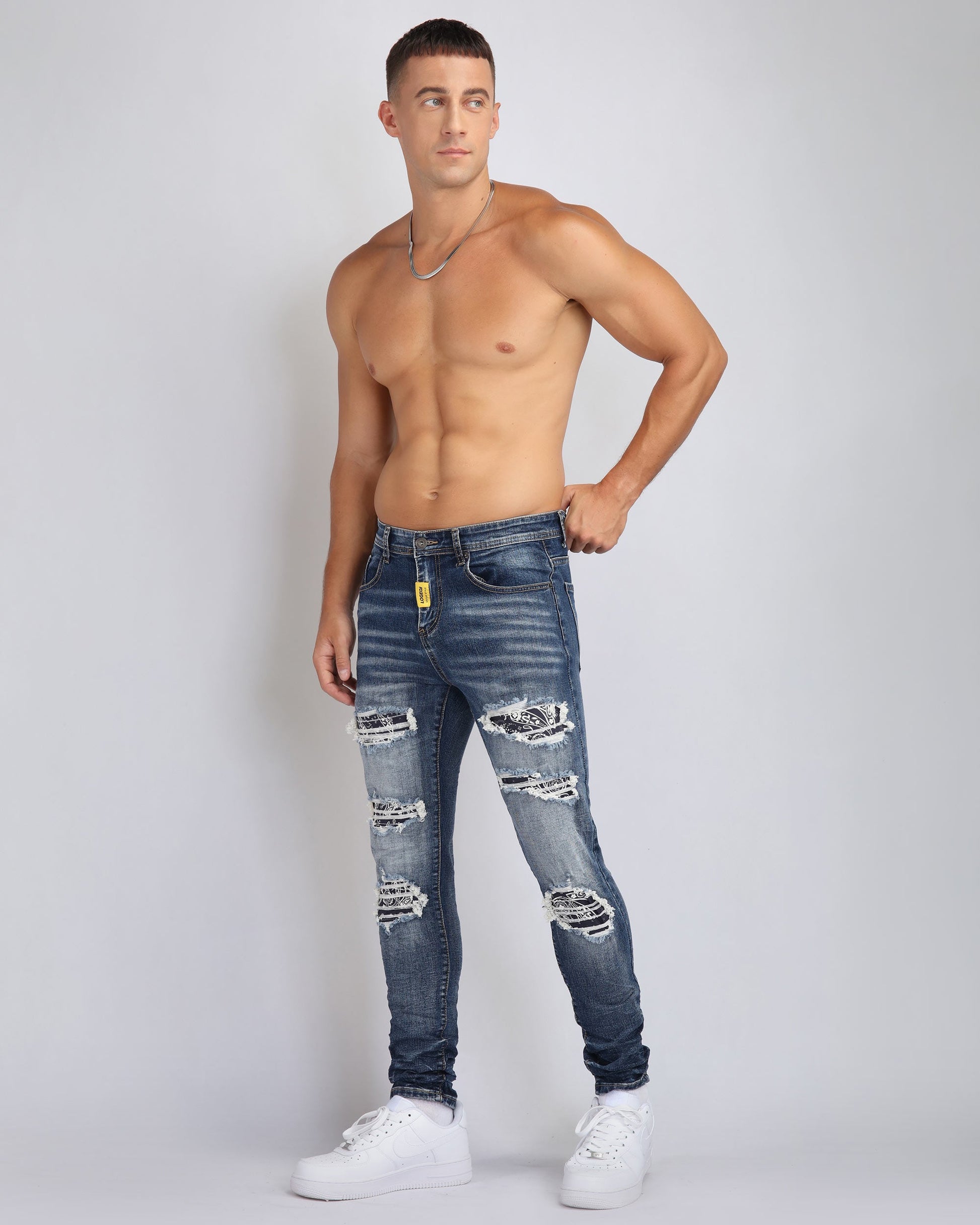 Stylish ripped blue jeans with flower patch, featuring a slim fit and distressed details for a modern look