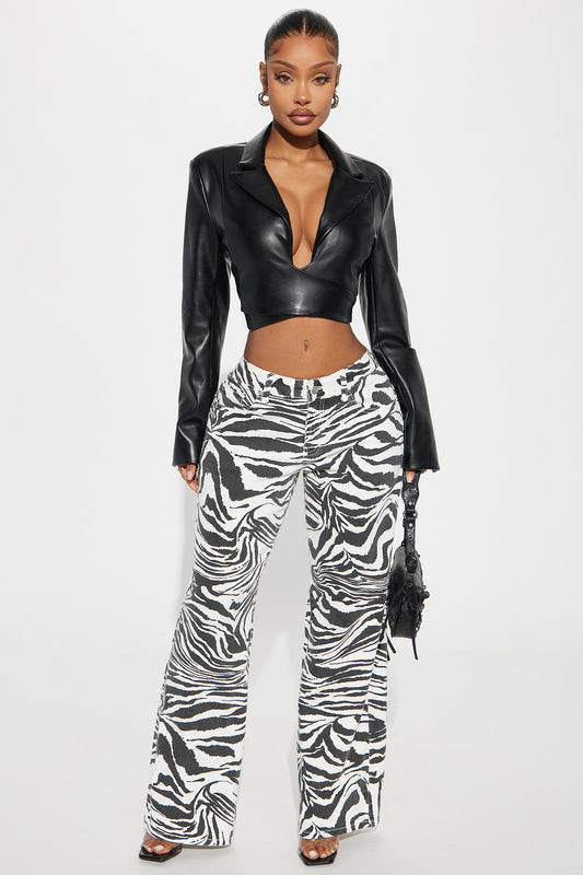 Fashion Nova zebra print wide leg jeans modeled with black cropped leather blazer and heels