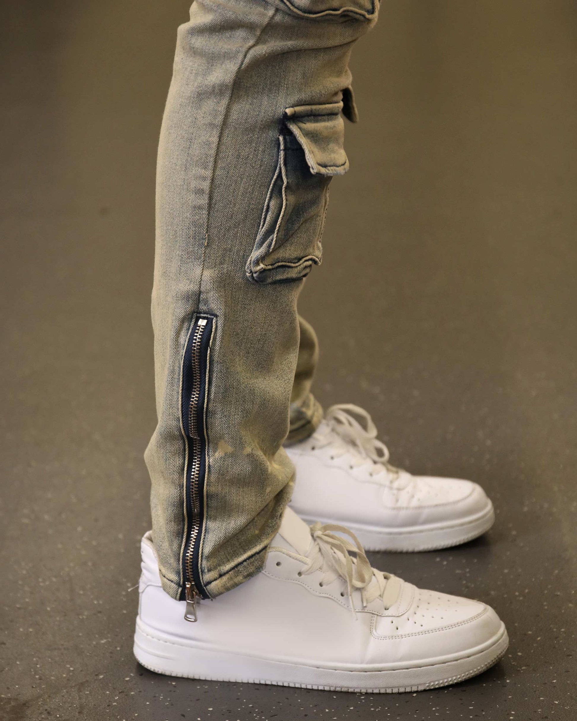 Logeqi spray painted blue cargo jeans with zippered cuffs worn with white sneakers