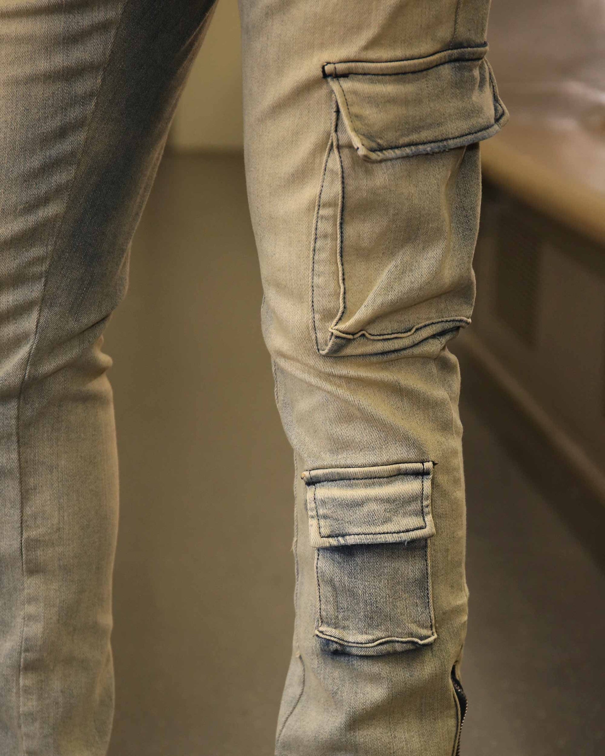Close-up of Logeqi spray painted blue cargo jeans showing detailed side pockets and stitching