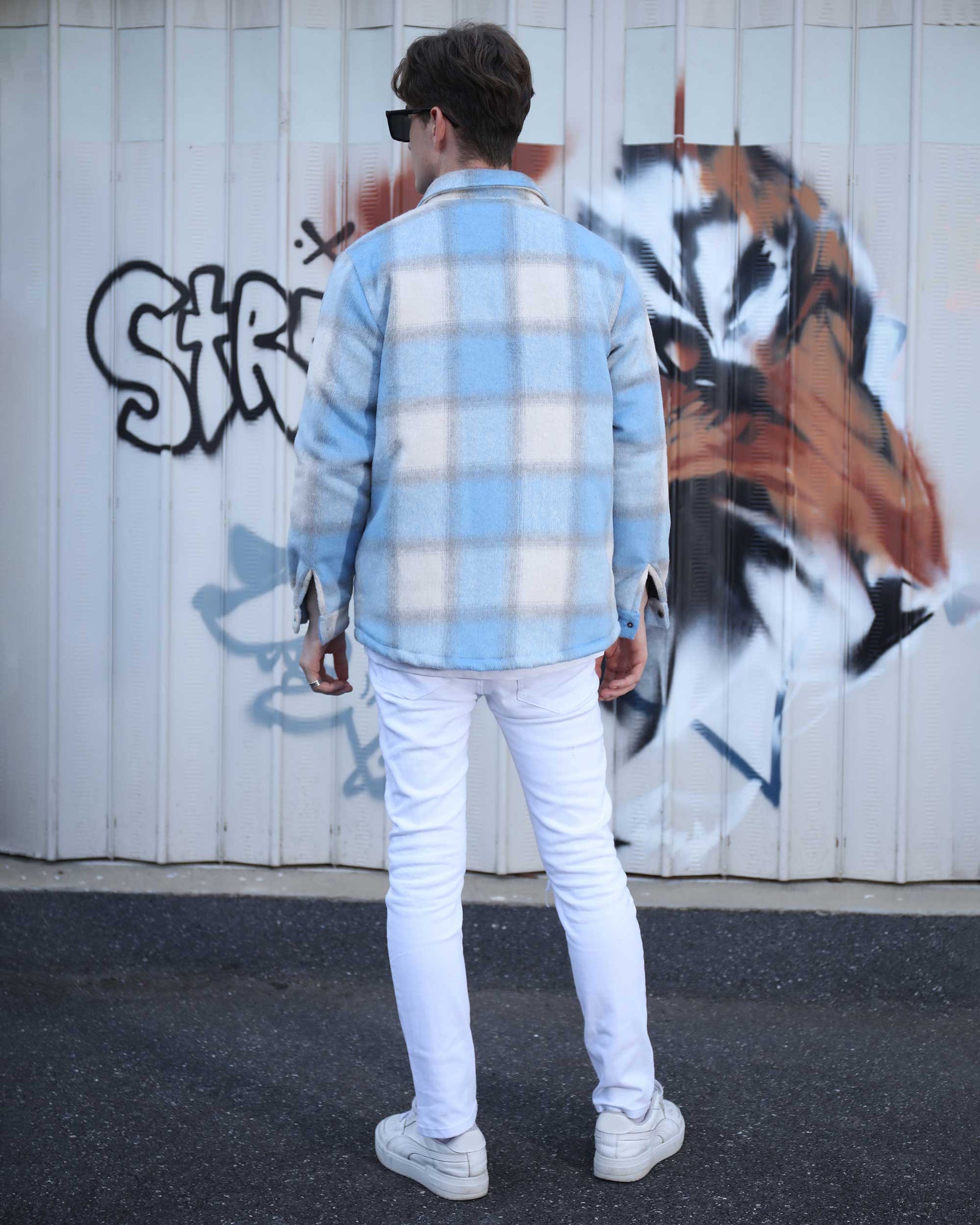 Logeqi spring plaid jacket in light blue and white worn by a man against graffiti wall