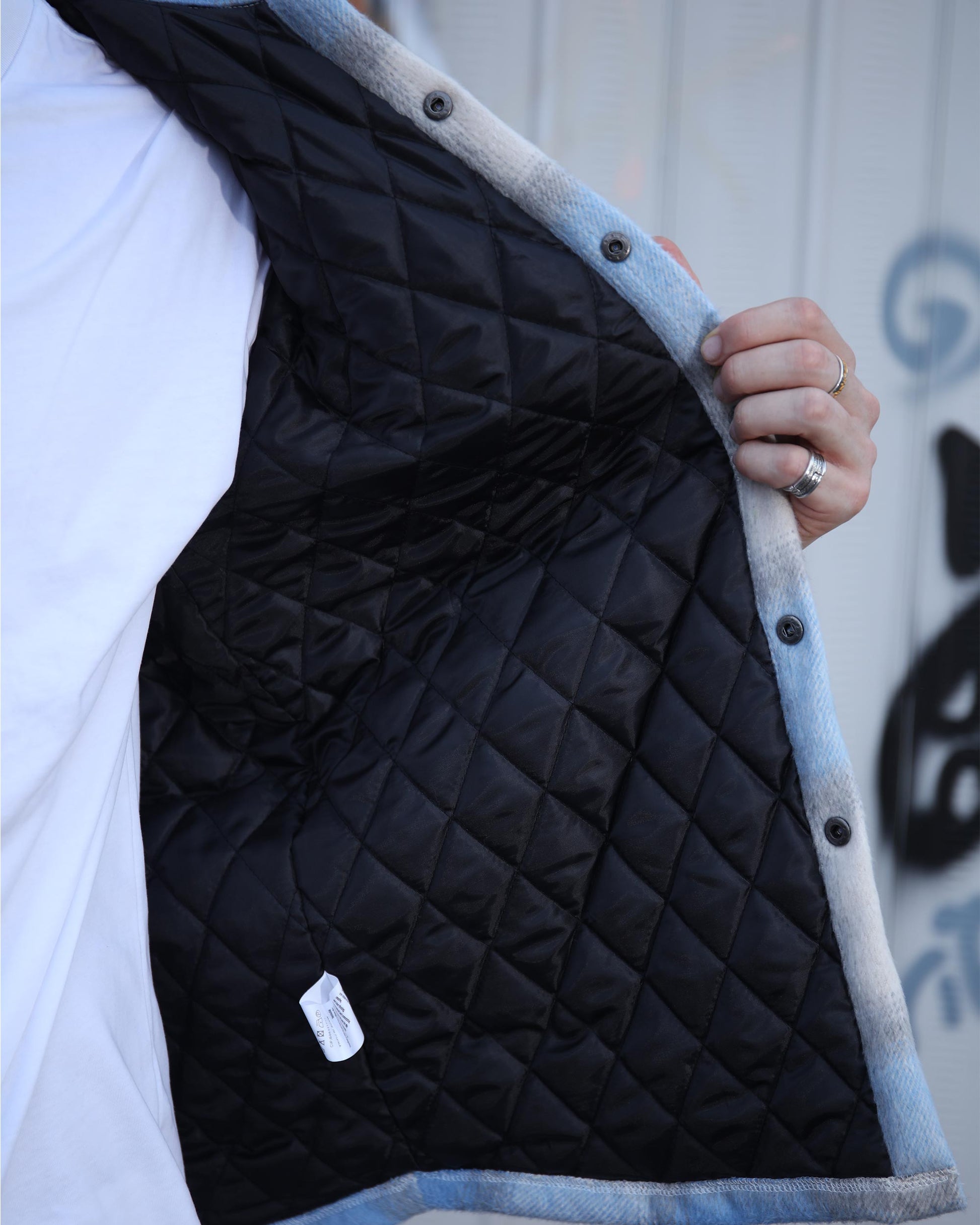 Logeqi spring plaid jacket showing black quilted inner lining with snap button closure