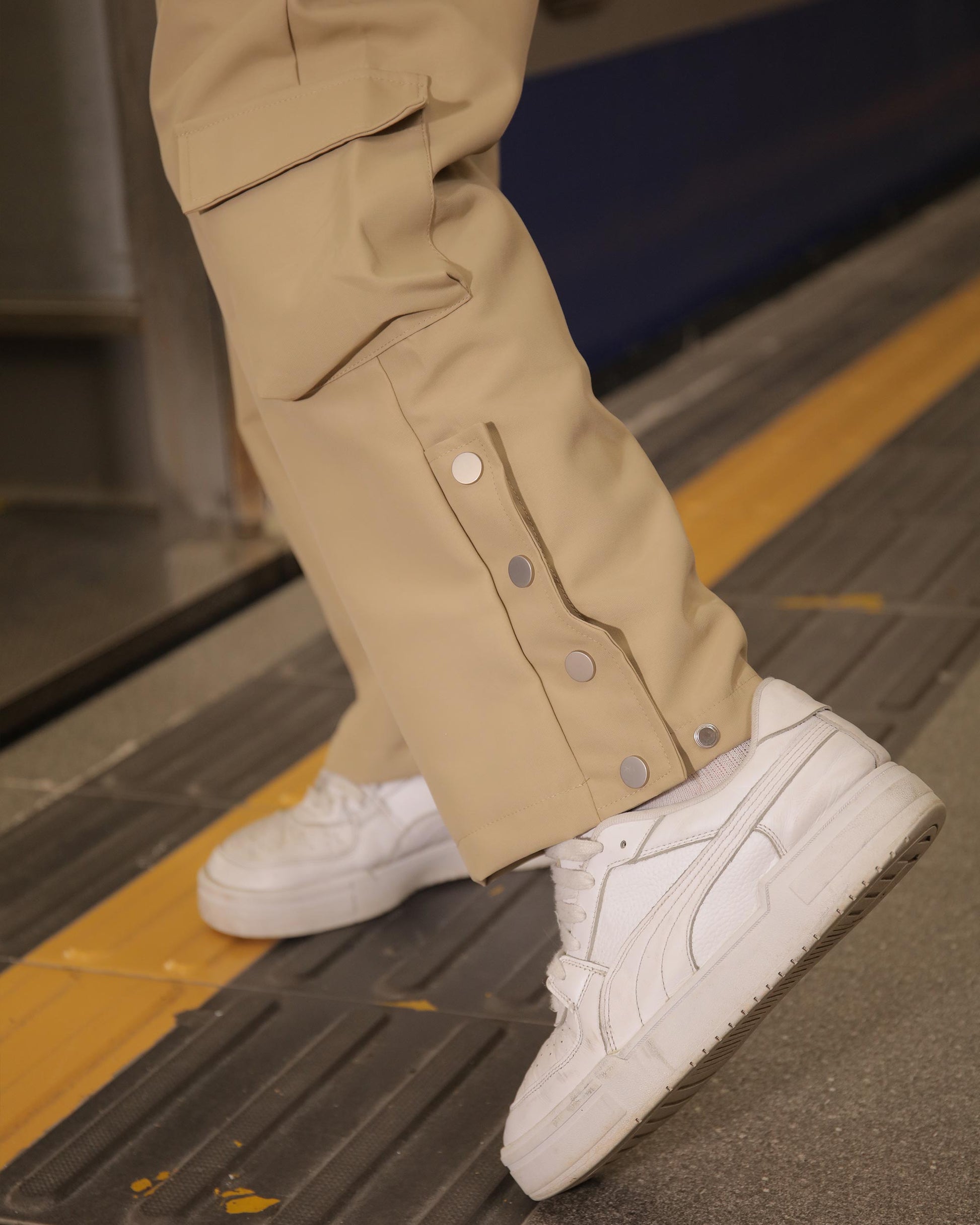 Logeqi stylish cargo pants for men in beige with snap button details paired with white sneakers