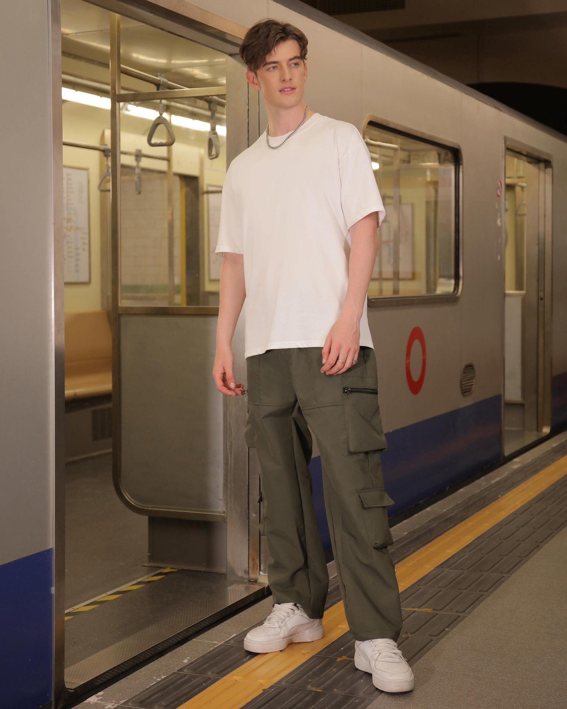Man wearing Logeqi stylish cargo pants for men in olive green with multiple pockets and white sneakers