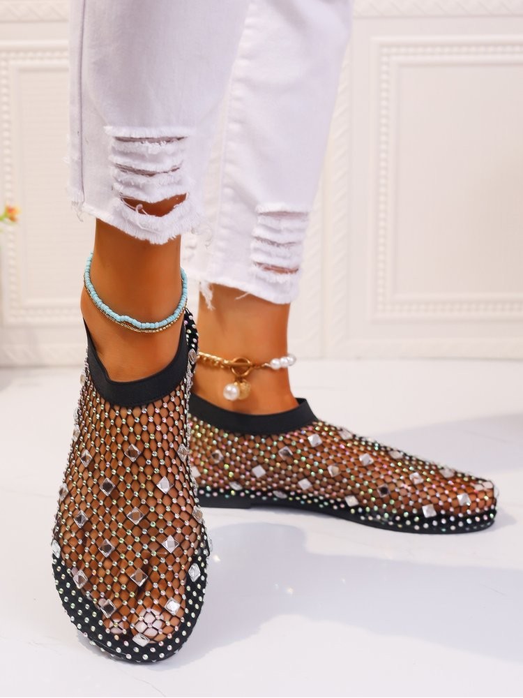 Stylish solid color sandals with black netted design and sparkling embellishments on feet