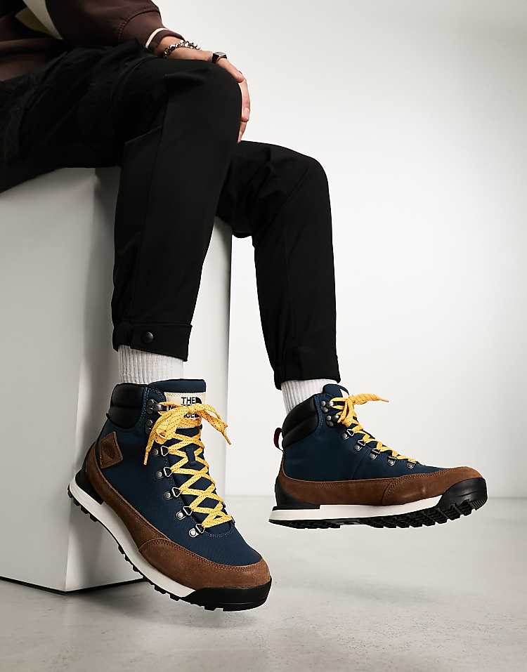 The North Face Back-To-Berkeley IV waterproof hiking boots in blue and brown worn by a person sitting down