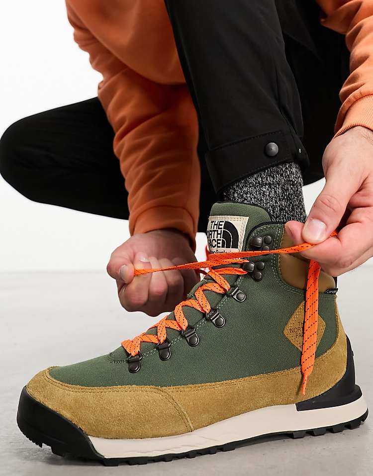 Man tying The North Face Back-To-Berkeley IV waterproof hiking boots in green and orange for outdoor activities