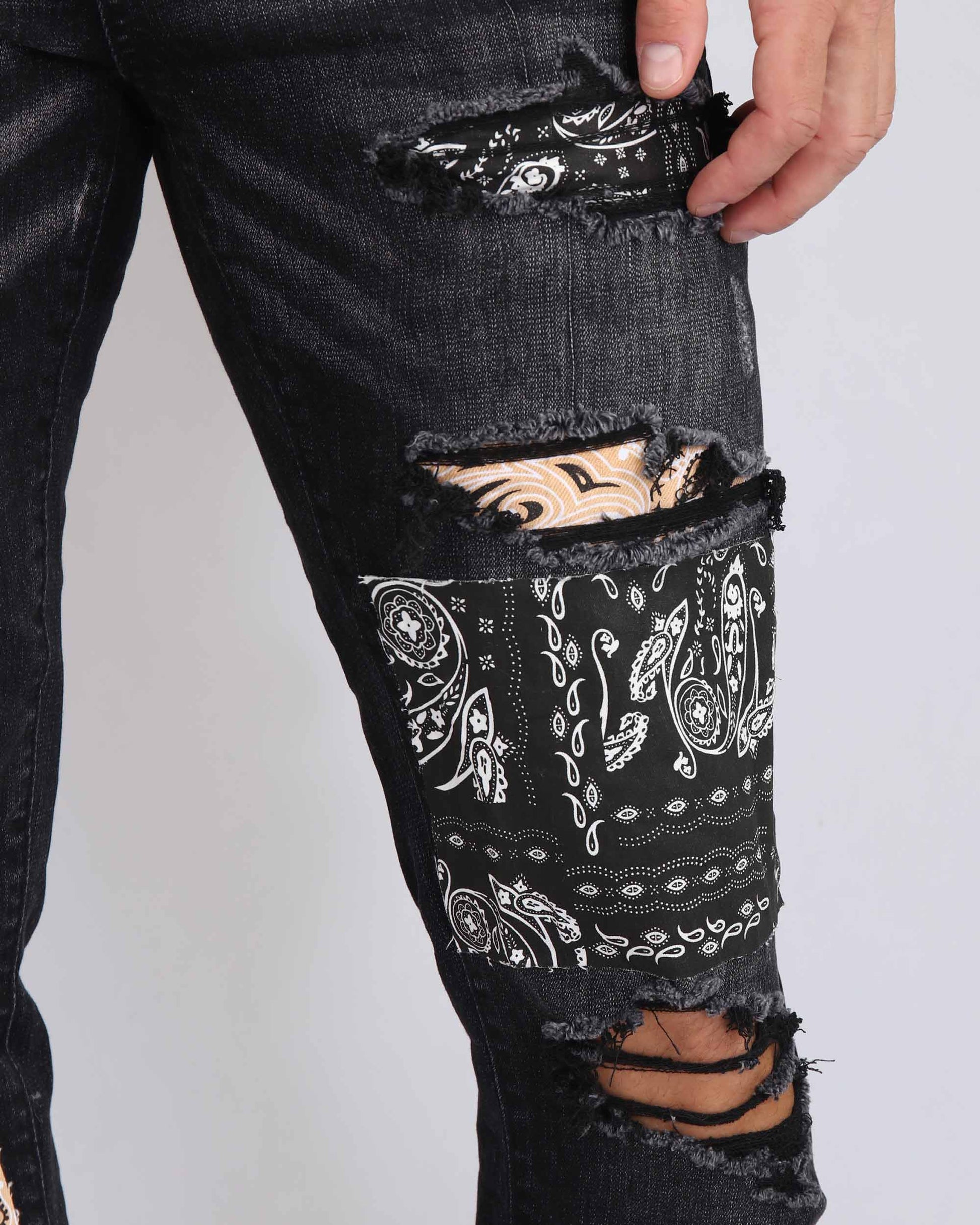 Trendy ripped black jeans with stylish bandana patches for a unique look