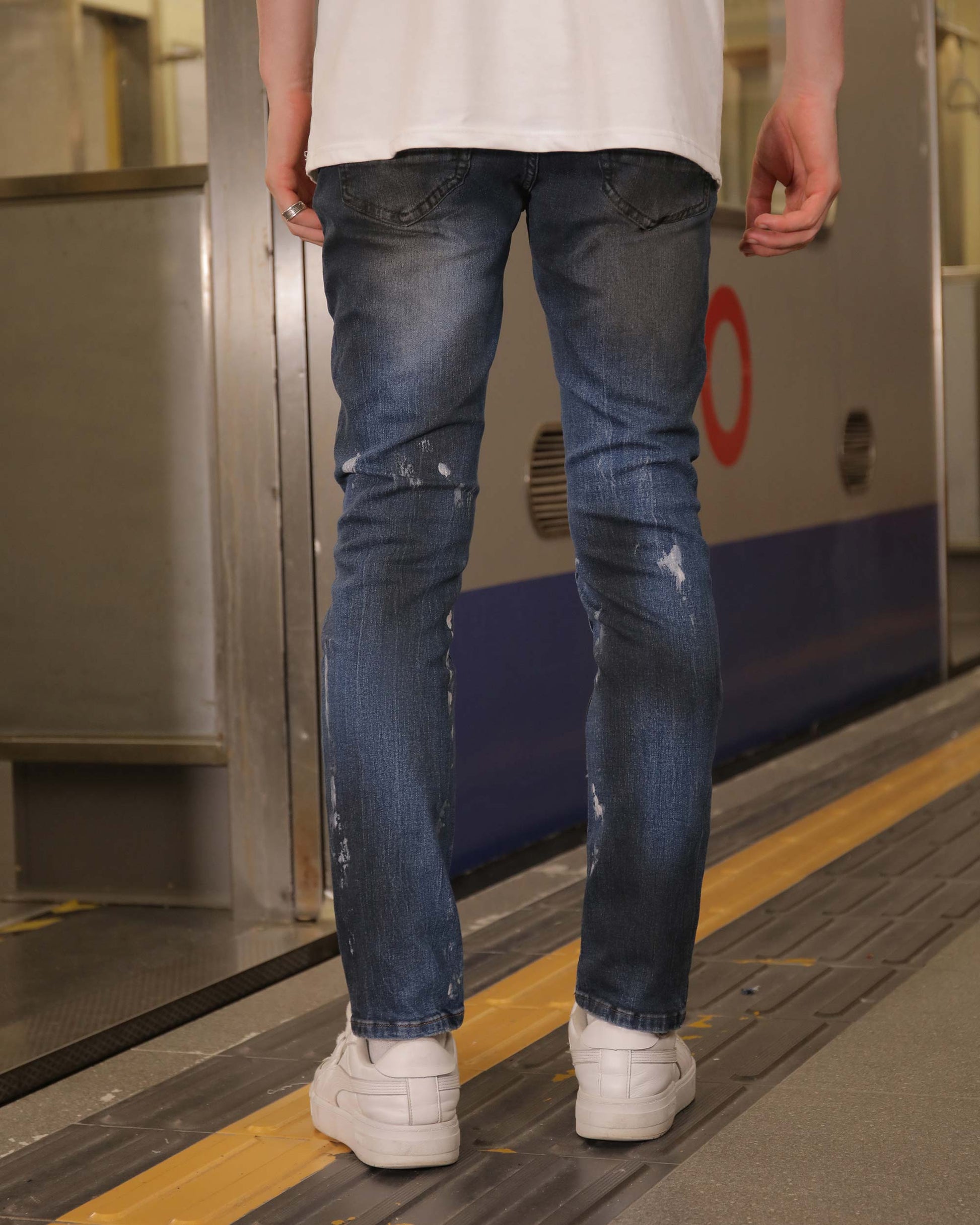 Logeqi unique blue wash jeans with distressed details worn by a person standing indoors