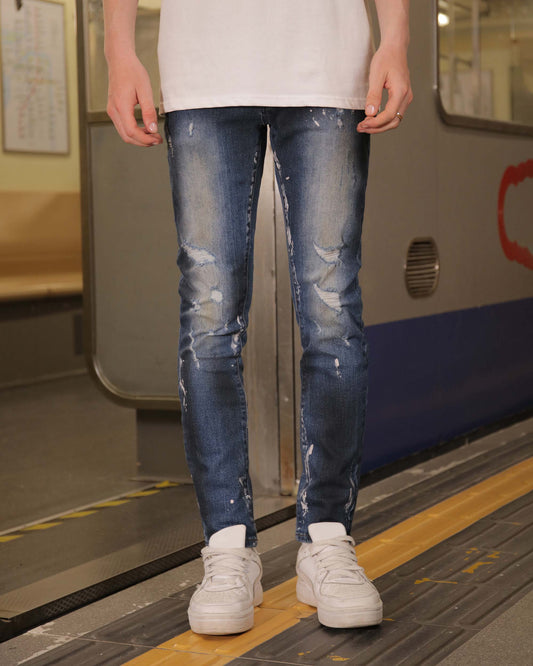 Logeqi unique blue wash jeans with distressed detailing worn with white sneakers