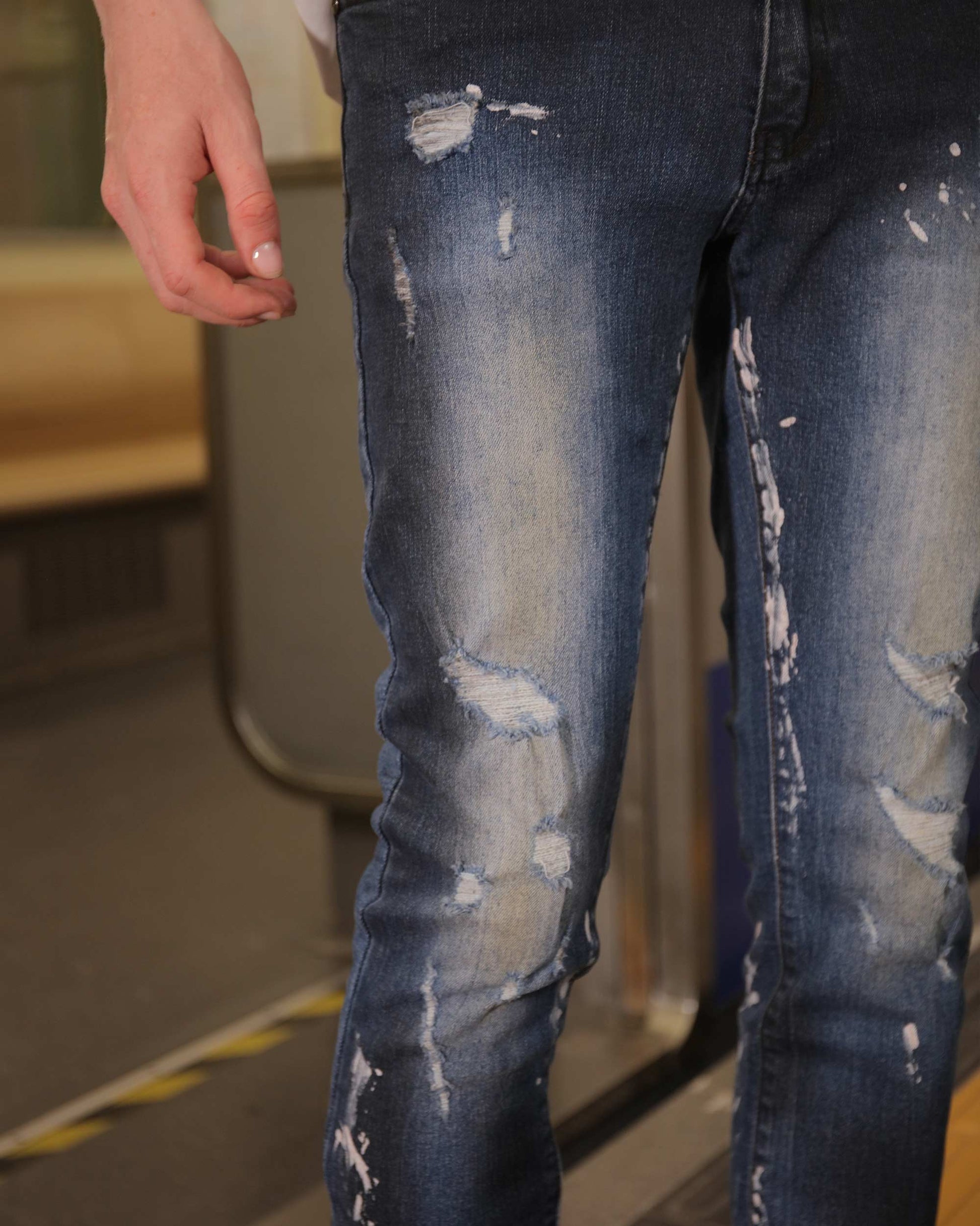 Logeqi unique blue wash jeans with distressed details on a person standing indoors