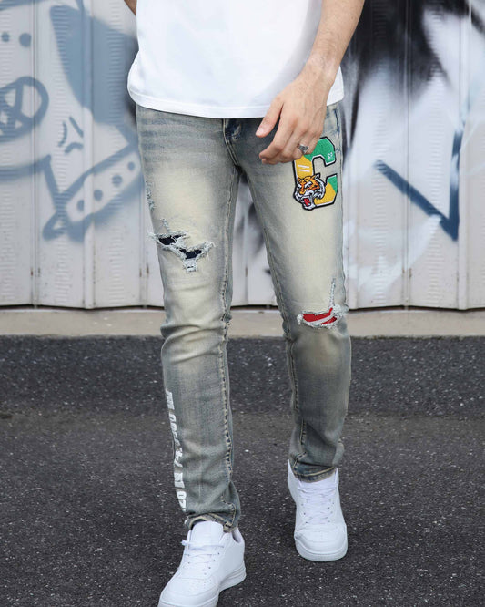 Logeqi distressed light wash jeans with ripped details and colorful patch design on the thigh