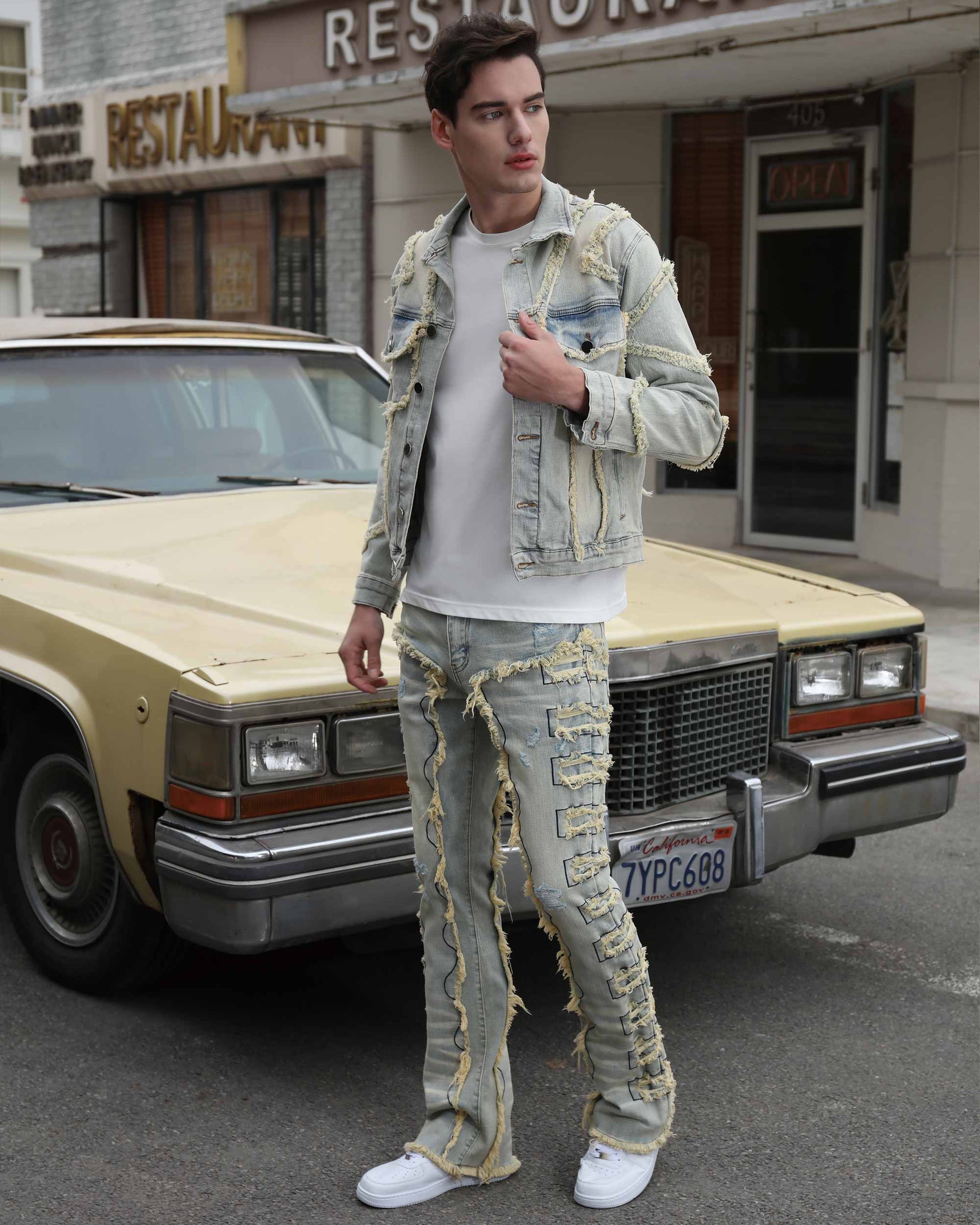 Logeqi vintage blue stacked jeans worn by man with distressed denim jacket and white sneakers