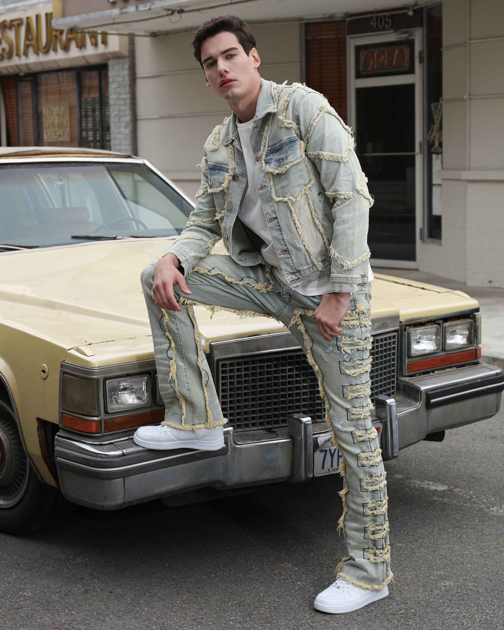 Logeqi vintage blue stacked jeans worn by male model leaning on vintage car