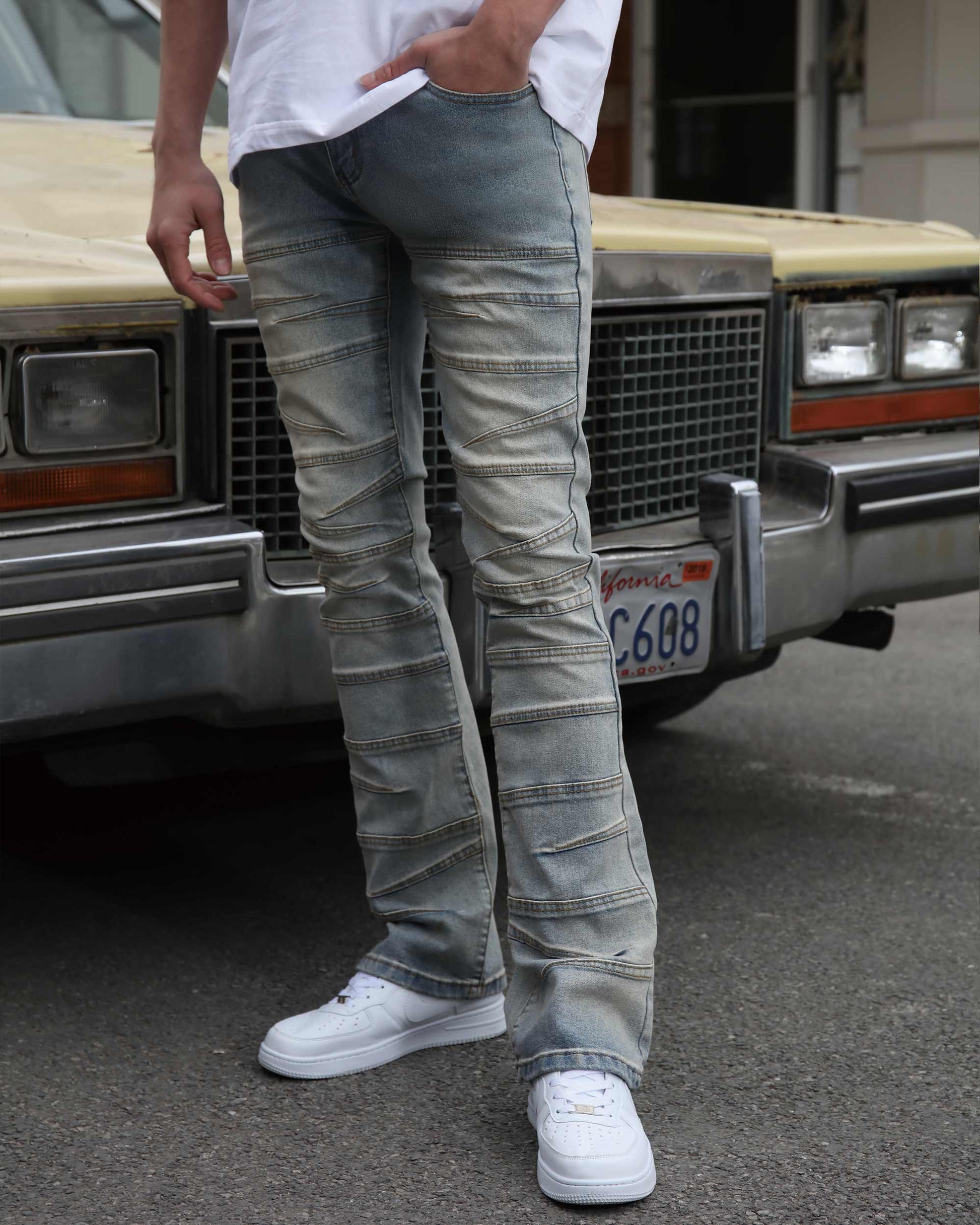Men wearing Logeqi vintage distressed blue jeans with ribbed knee details and white sneakers