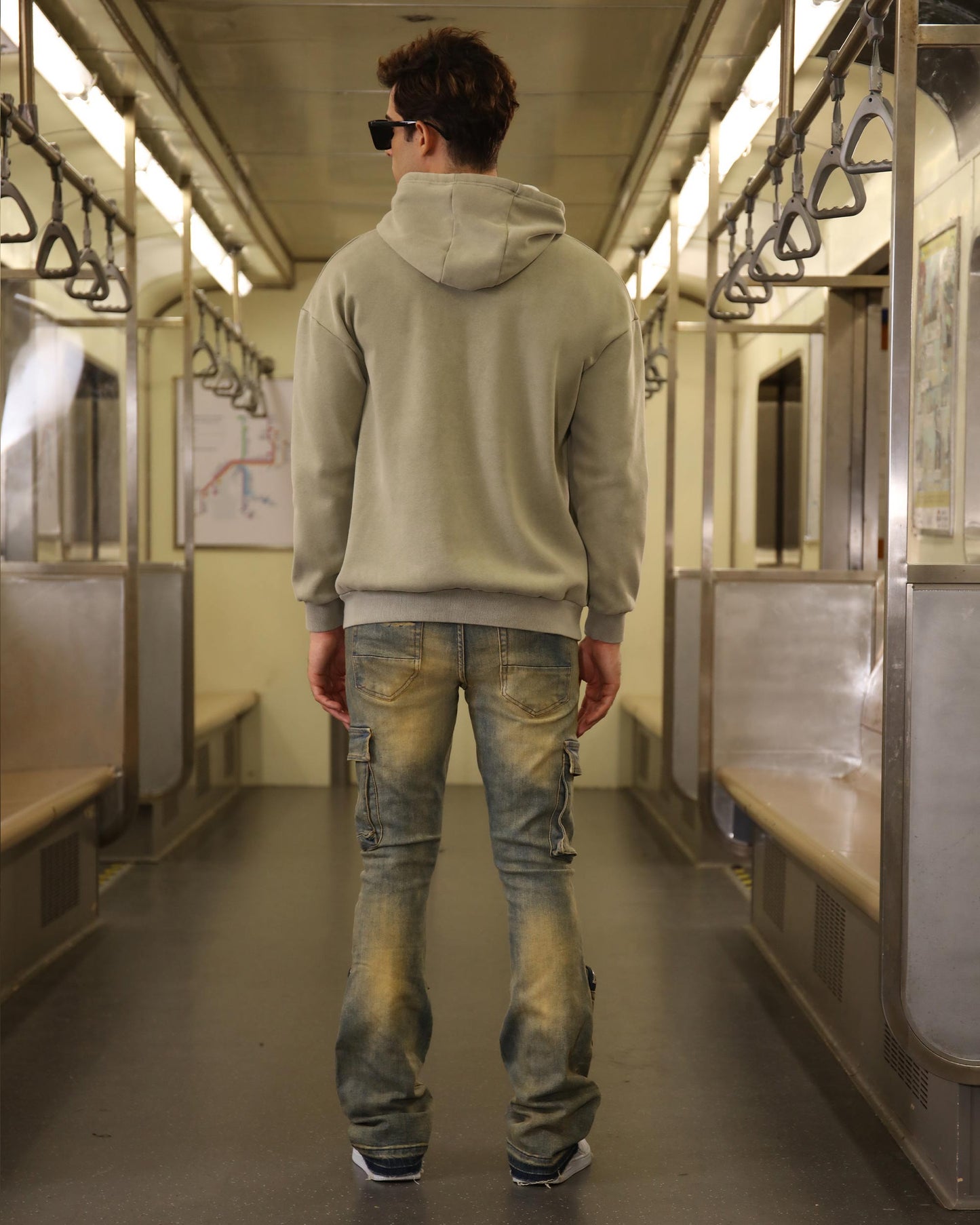 Logeqi vintage distressed cargo jeans on a model in a subway with a casual hoodie style