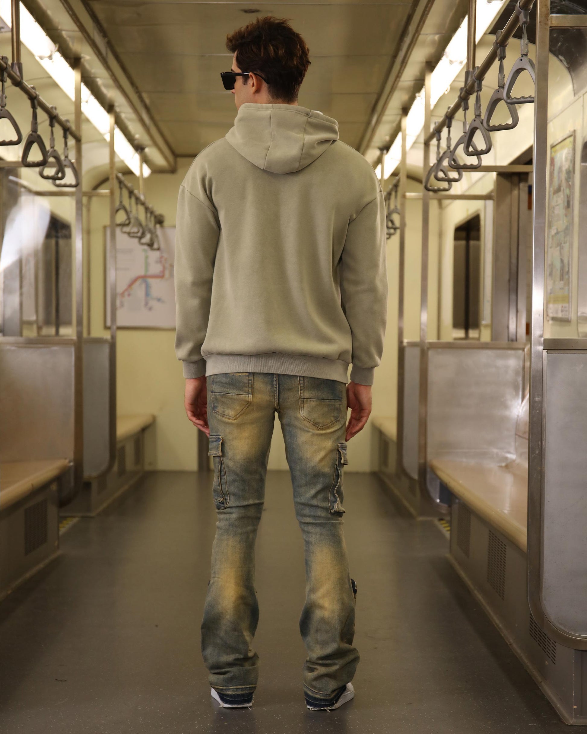 Logeqi vintage distressed cargo jeans on a model in a subway with a casual hoodie style