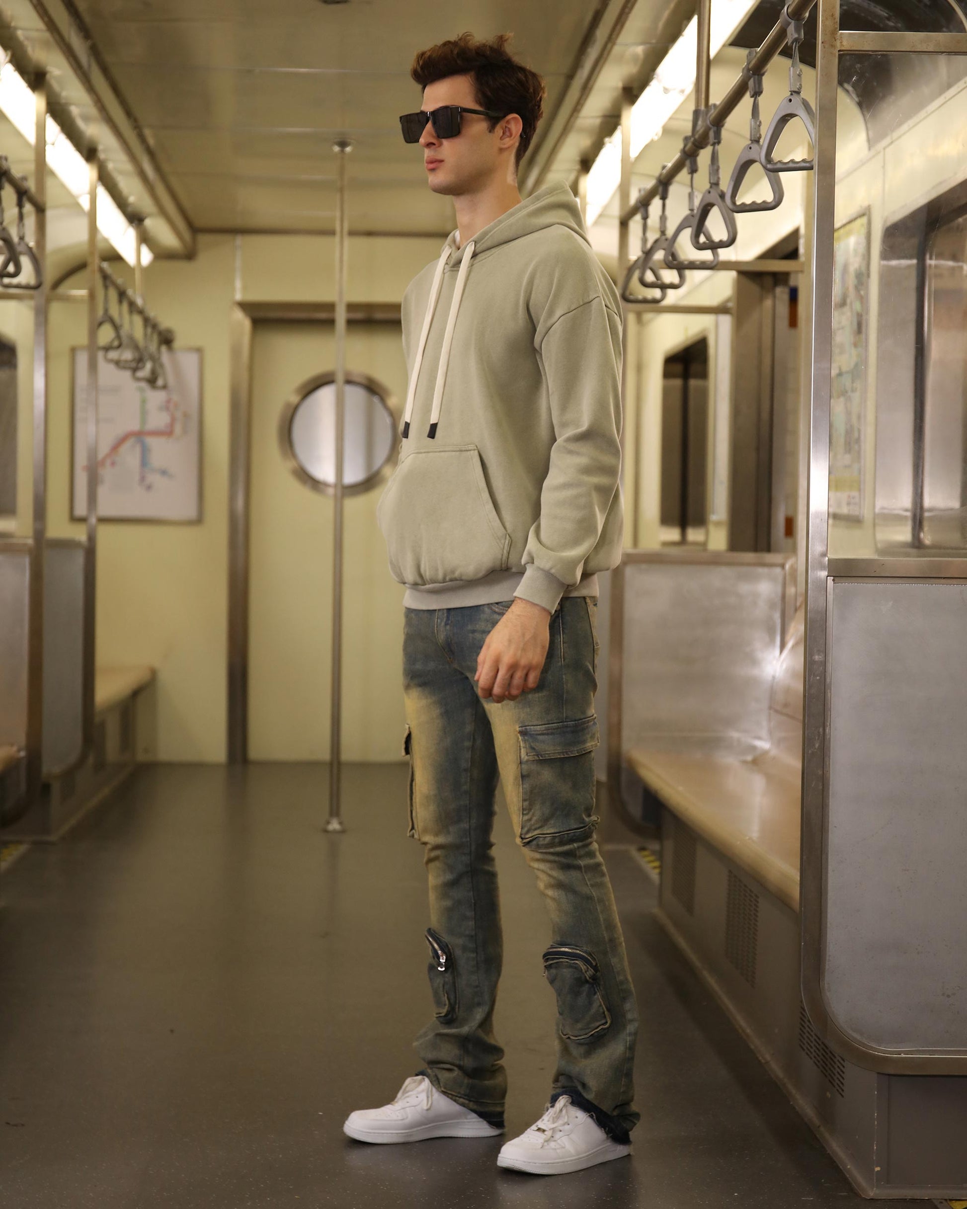 Logeqi vintage distressed cargo jeans styled with a hoodie in a subway setting
