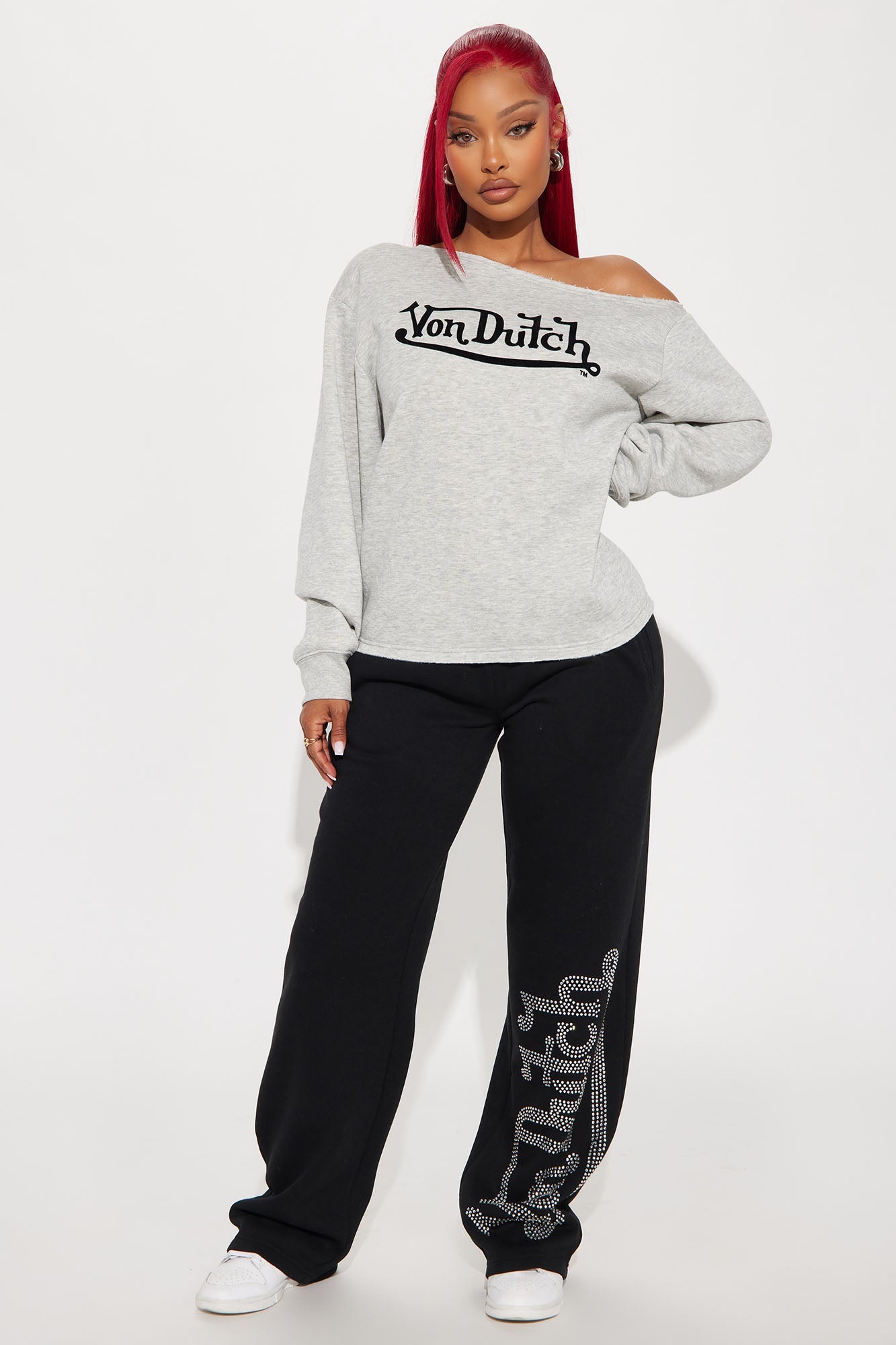 Von Dutch off shoulder sweatshirt in gray paired with black sweatpants featuring a logo design