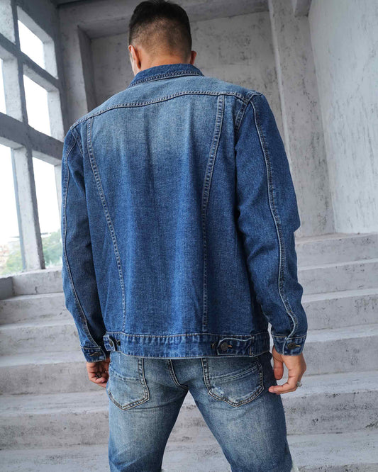 Back view of a Logeqi washed blue denim jacket on a model standing on stairs