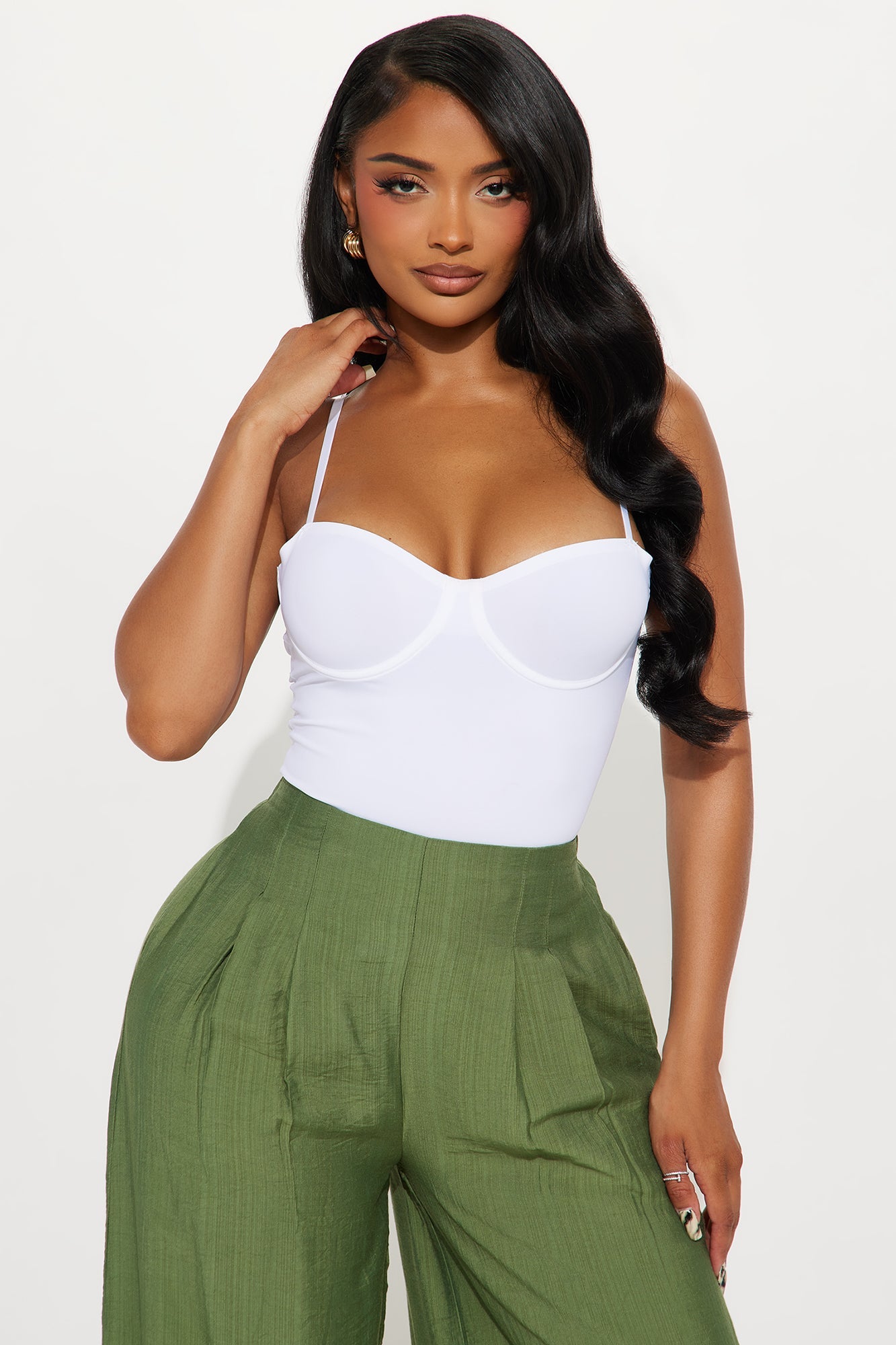 Fashion Nova white seamless bodysuit with adjustable straps paired with stylish green high-waisted pants